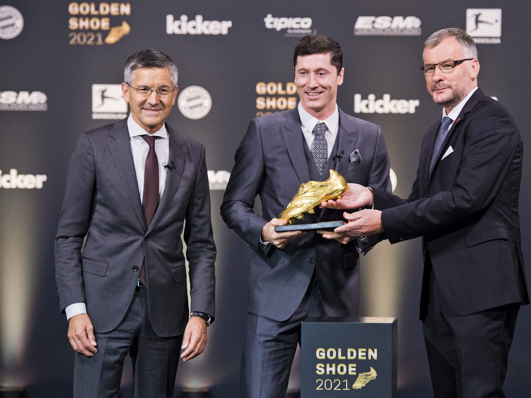 Jörg Jakob überreicht Robert Lewandwoski den Goldenen Schuh. Herbert Hainer steht daneben