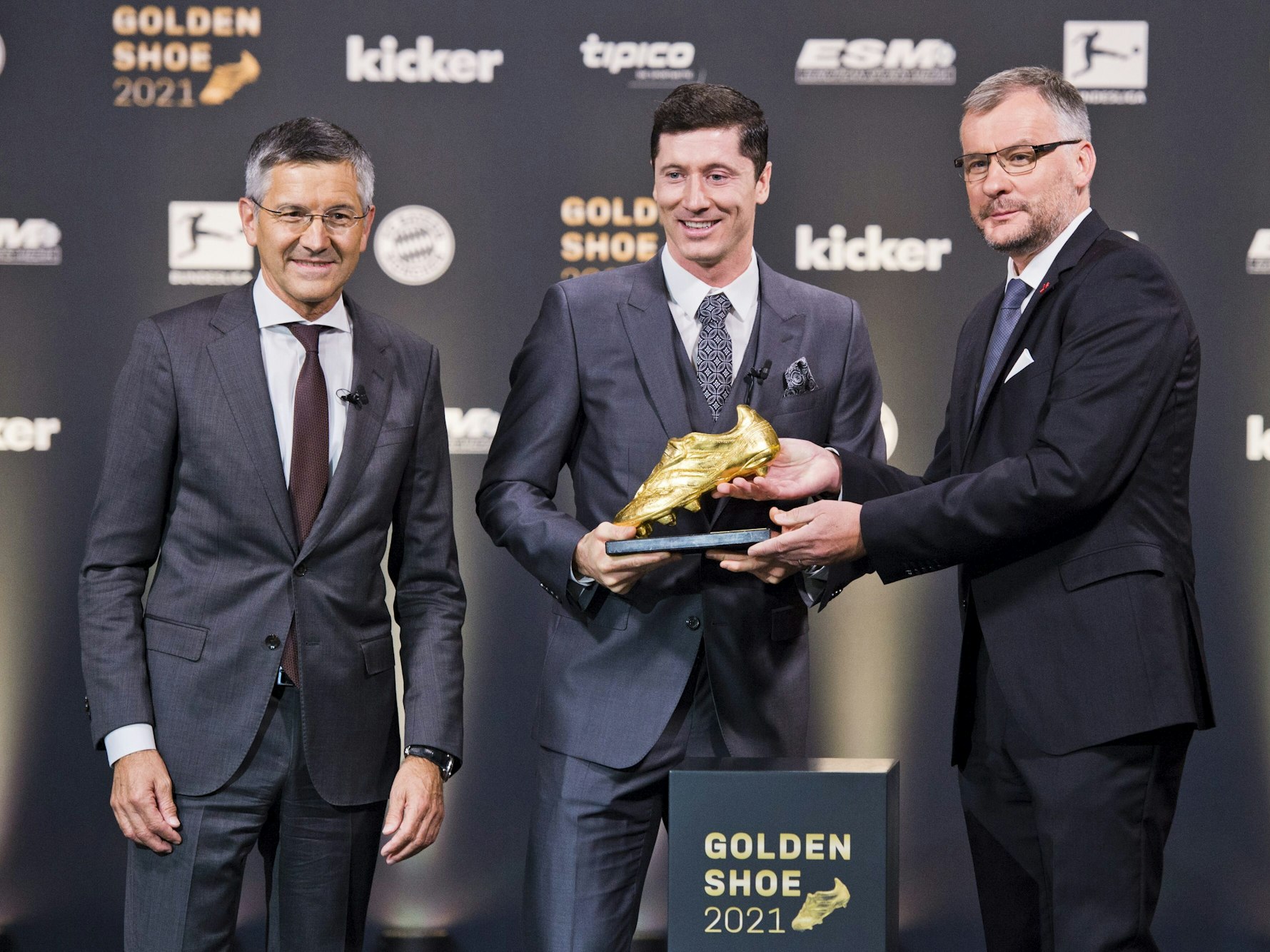 Jörg Jakob überreicht Robert Lewandwoski den Goldenen Schuh. Herbert Hainer steht daneben