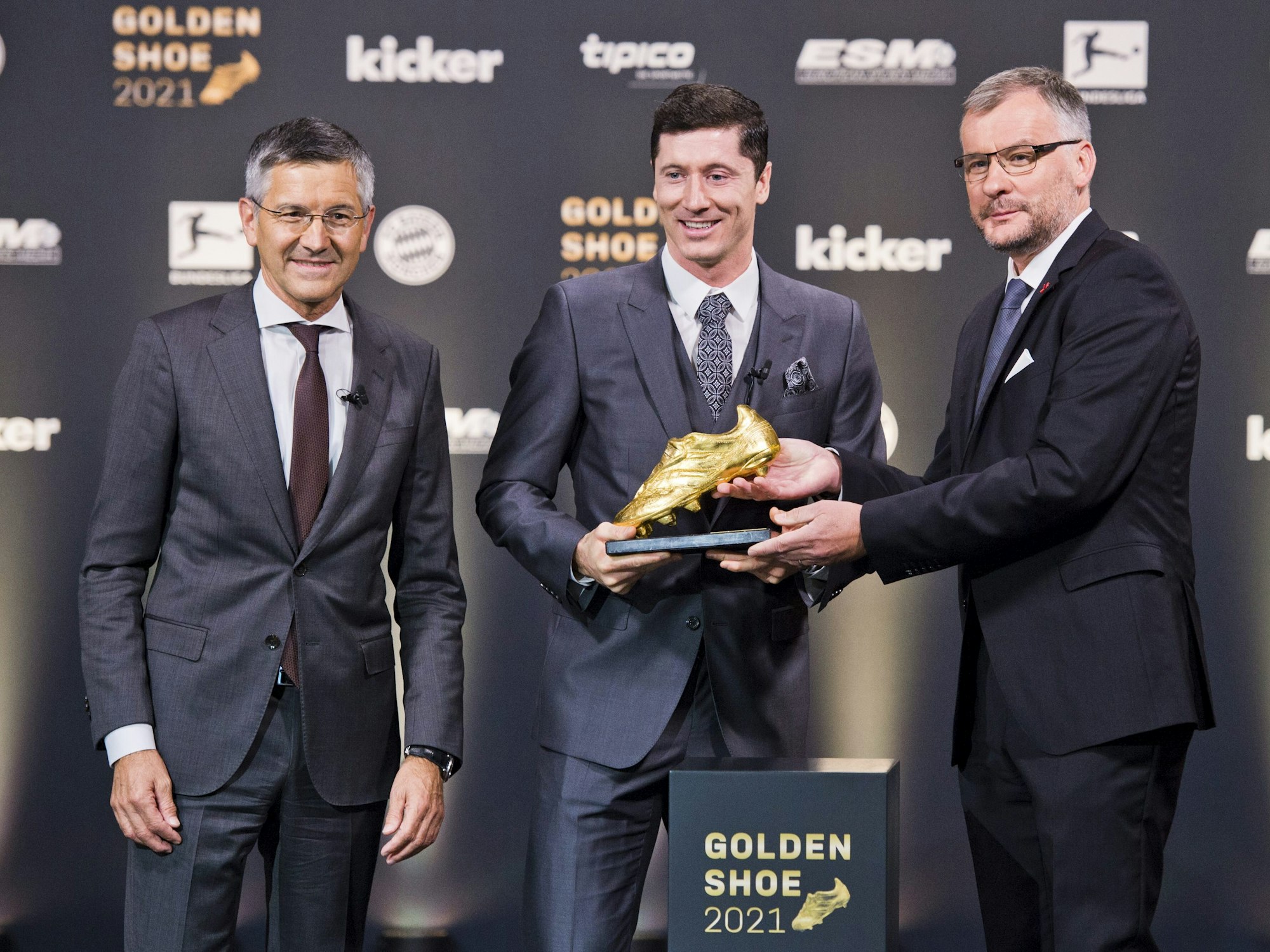 Jörg Jakob überreicht Robert Lewandwoski den Goldenen Schuh. Herbert Hainer steht daneben