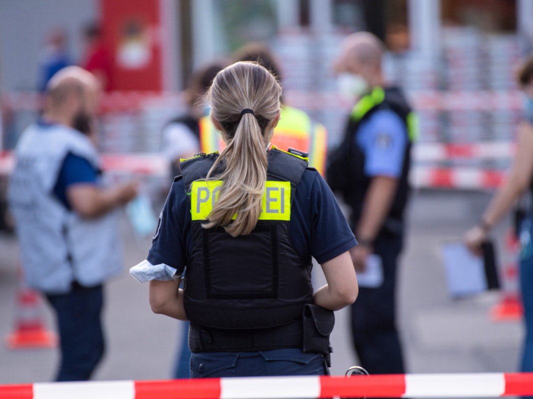 Polizisten auf dem Parkplatz eines Baumarkts.