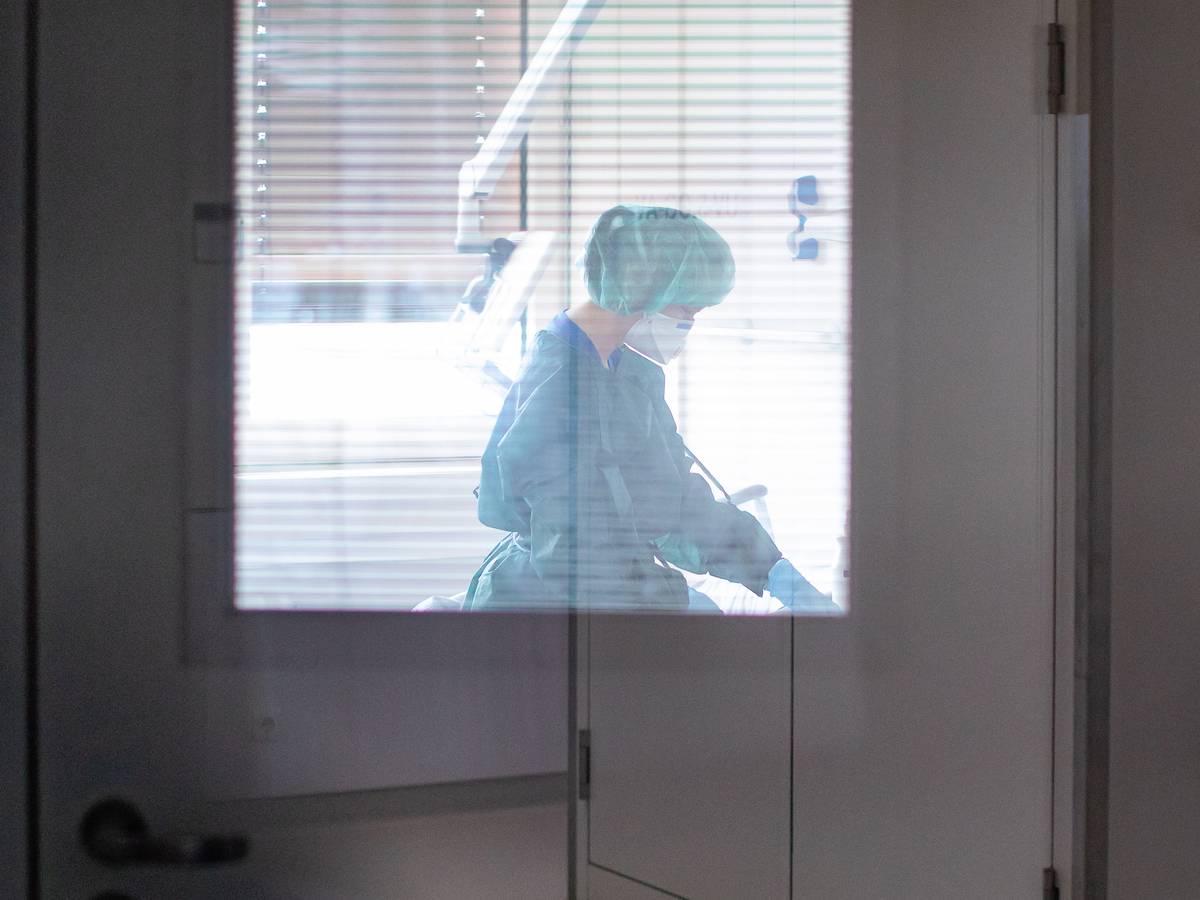 Eine Krankenschwester auf der Infektionsstation der Uniklinik Essen versorgt am 28. Februar 2020 in Schutzkleidung und mit einer Atemmaske einen Patienten. (