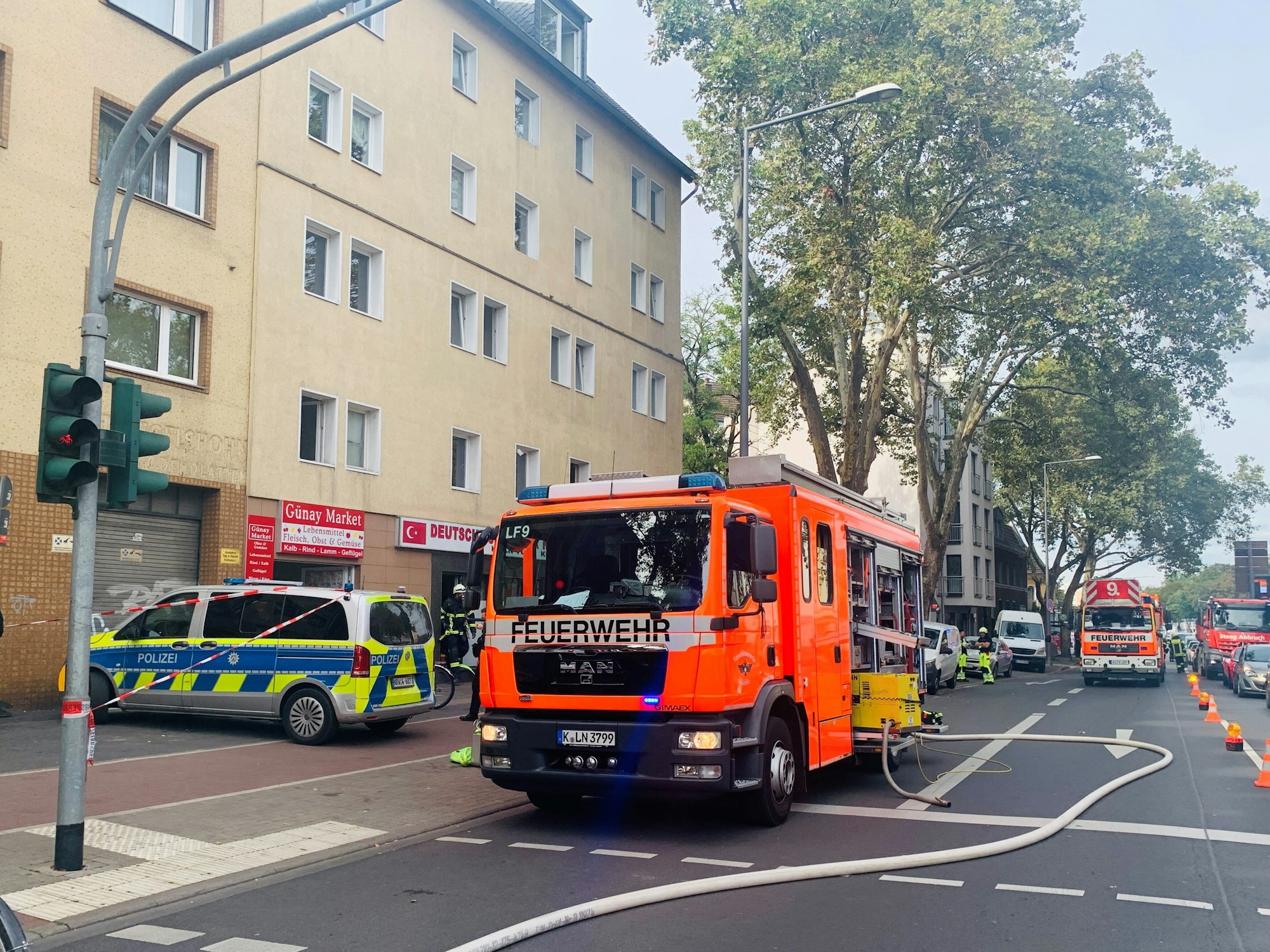 Feuerwehrfahrzeuge stehen vor einem Gebäude.