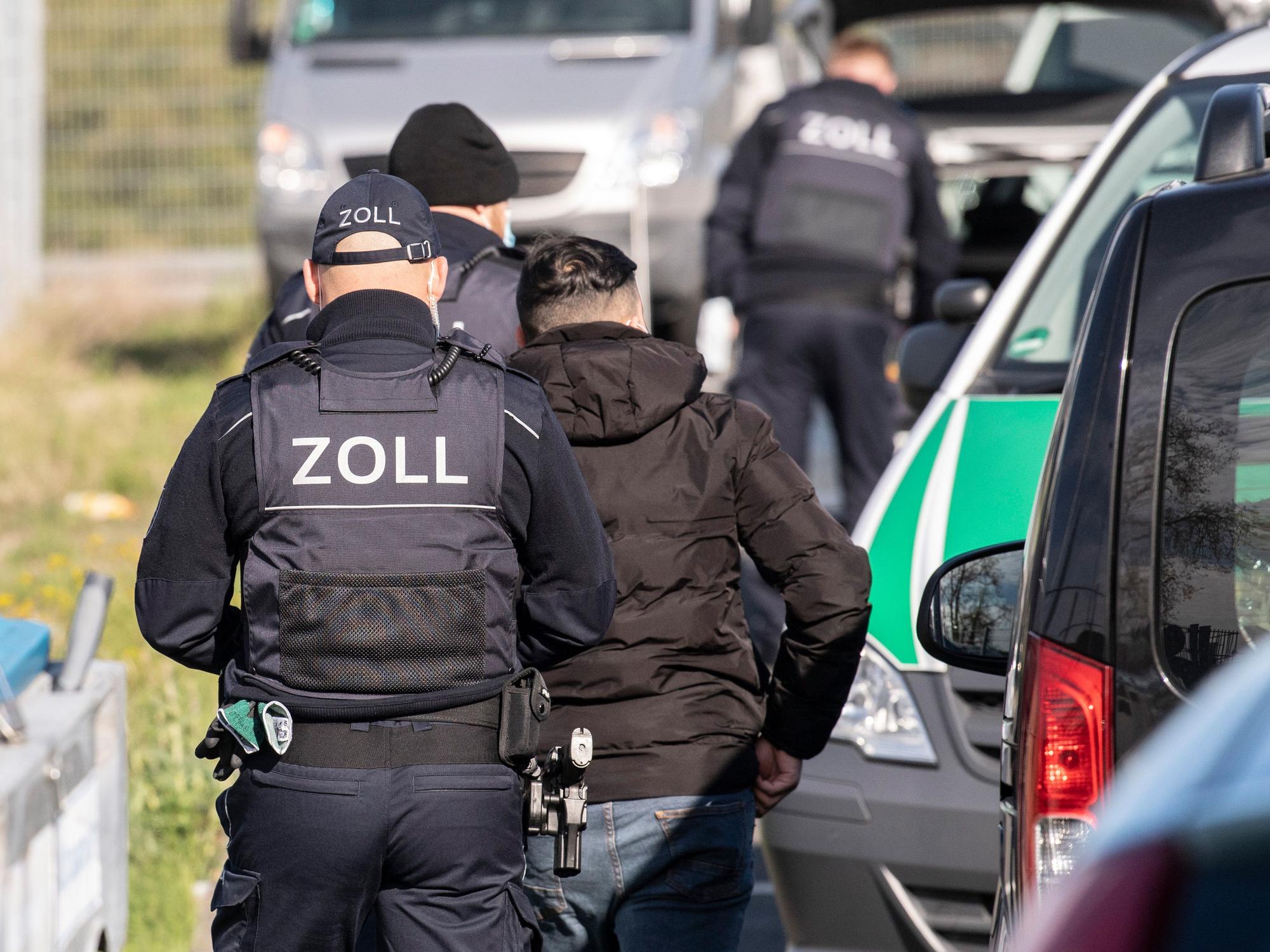 Mitarbeiter des Zolls gehen zu einer Razzia.