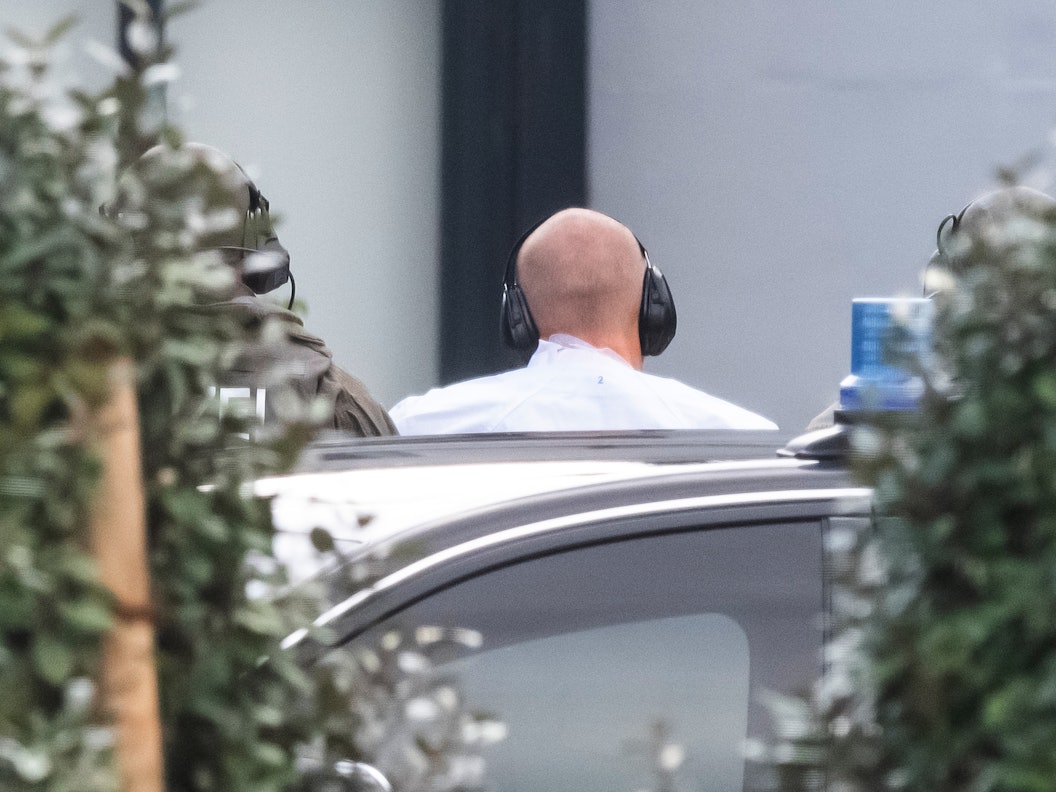 Der Halle-Attentäter Stephan B. wird im Oktober 2019 zur Außenstelle des Bundesgerichtshofs gebracht, er hat einen Ohrschutz auf und ist von hinten zu sehen.