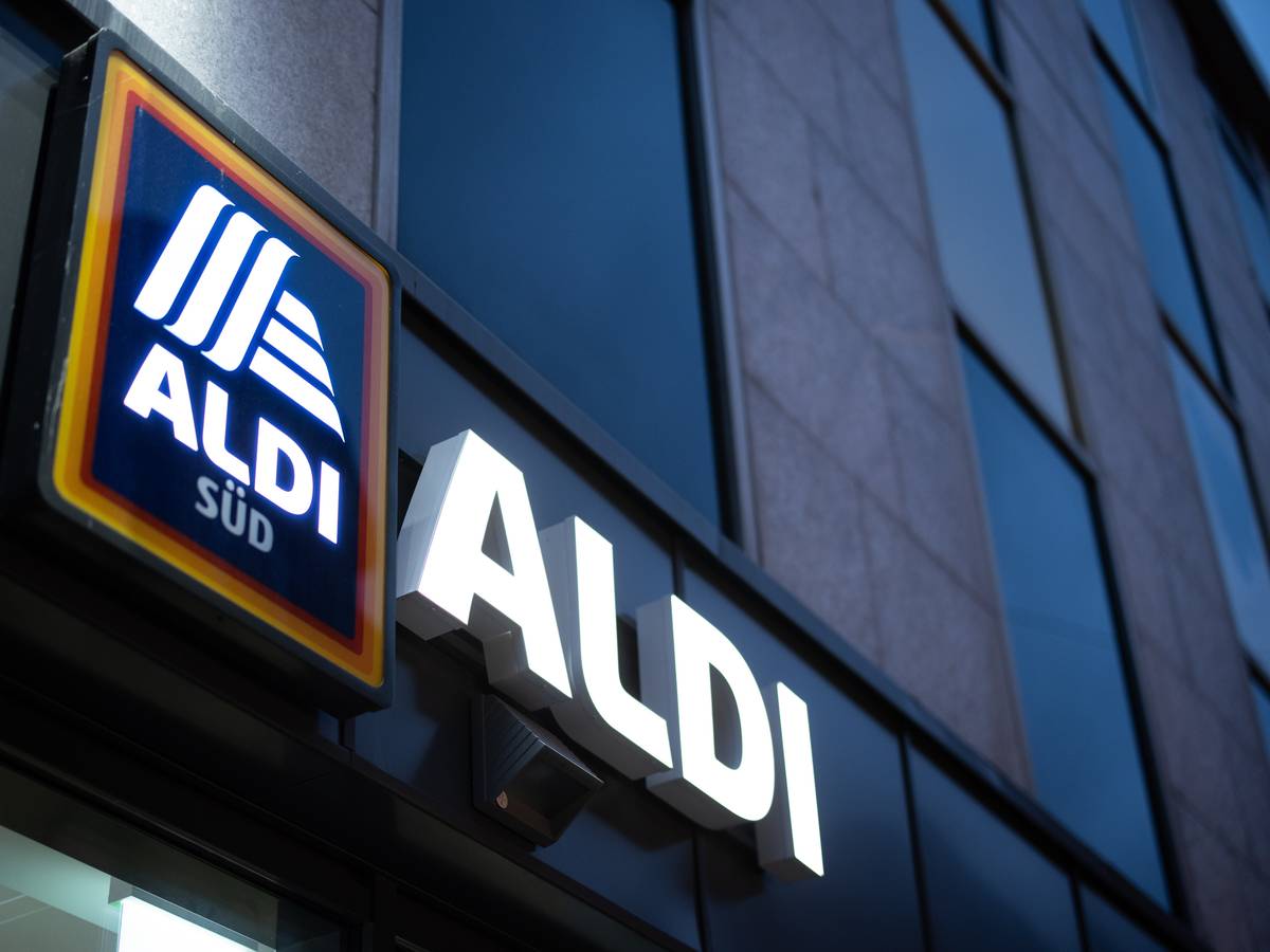 Das Logo einer Aldi Süd Filiale, fotografiert im November 2020 in einer Fußgängerzone der Düsseldorfer Innenstadt. Das Logo leuchtet, es ist Abend.