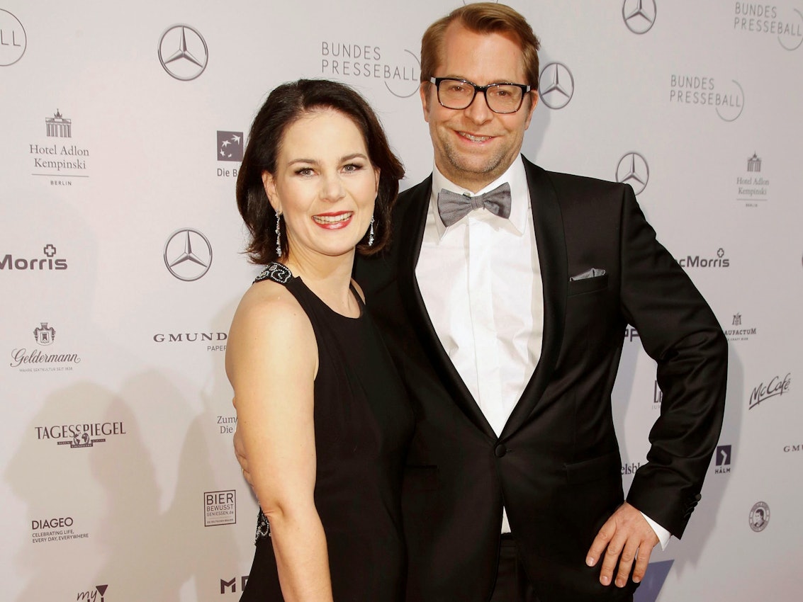 Annalena Baerbock mit Ehemann Daniel Holefleisch auf dem Roten Teppich beim Bundespresseball im Hotel Adlon Kempinski in Berlin. Er trägt einen schwarzen Anzug, sie ein schwarzes Kleid.