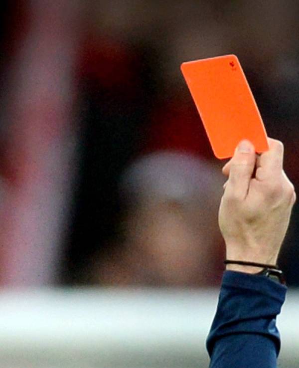 Ein Schiedsrichter zeigt einem Fußballspieler die Rote Karte.