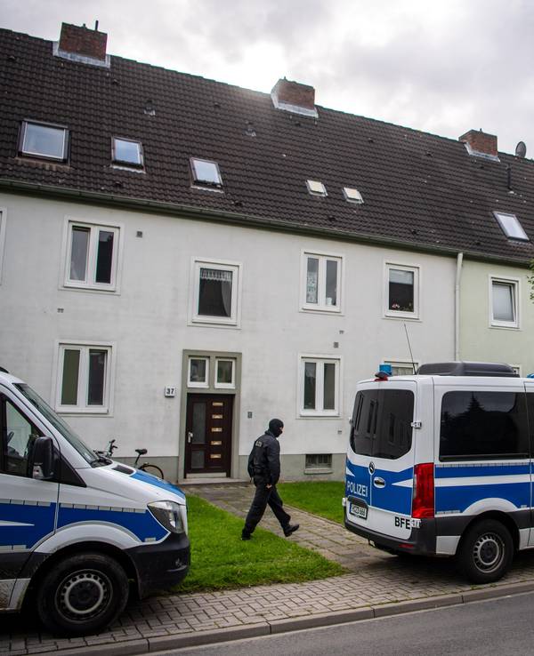 Polizei-Autos vor einem Mehrfamilienhaus.