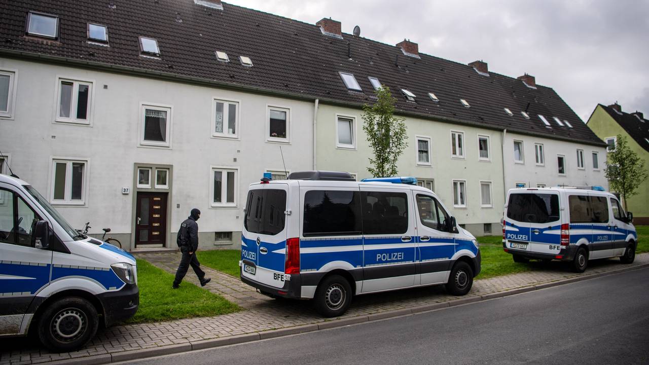 Polizei-Autos vor einem Mehrfamilienhaus.