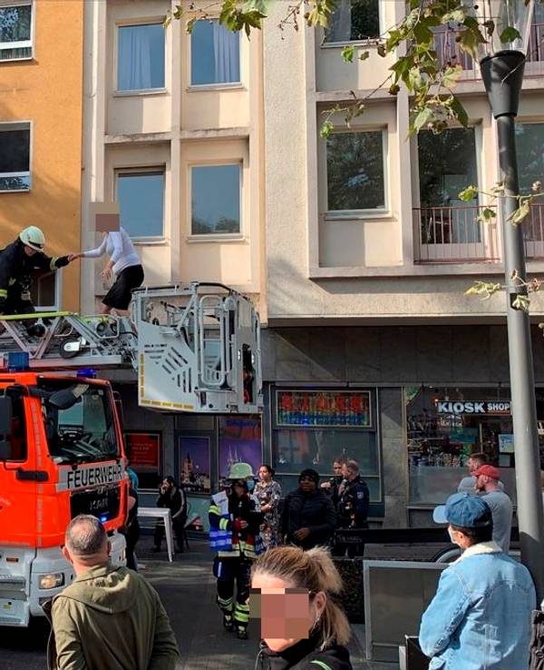 Eine Frau wird von der Feuerwehr über die Drehleiter gerettet.
