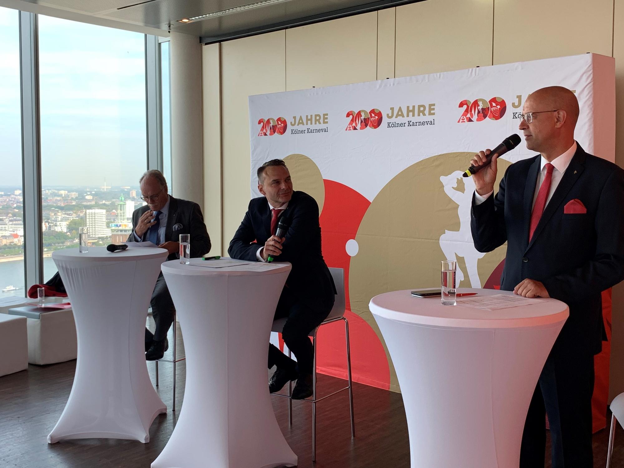 Kölnkongress-Chef Bernhard Conin, Holger Kirsch und FK-Sprecher Michael Kramp (v.l.) stehen an drei Pulten mit Mikrofonen in der Hand