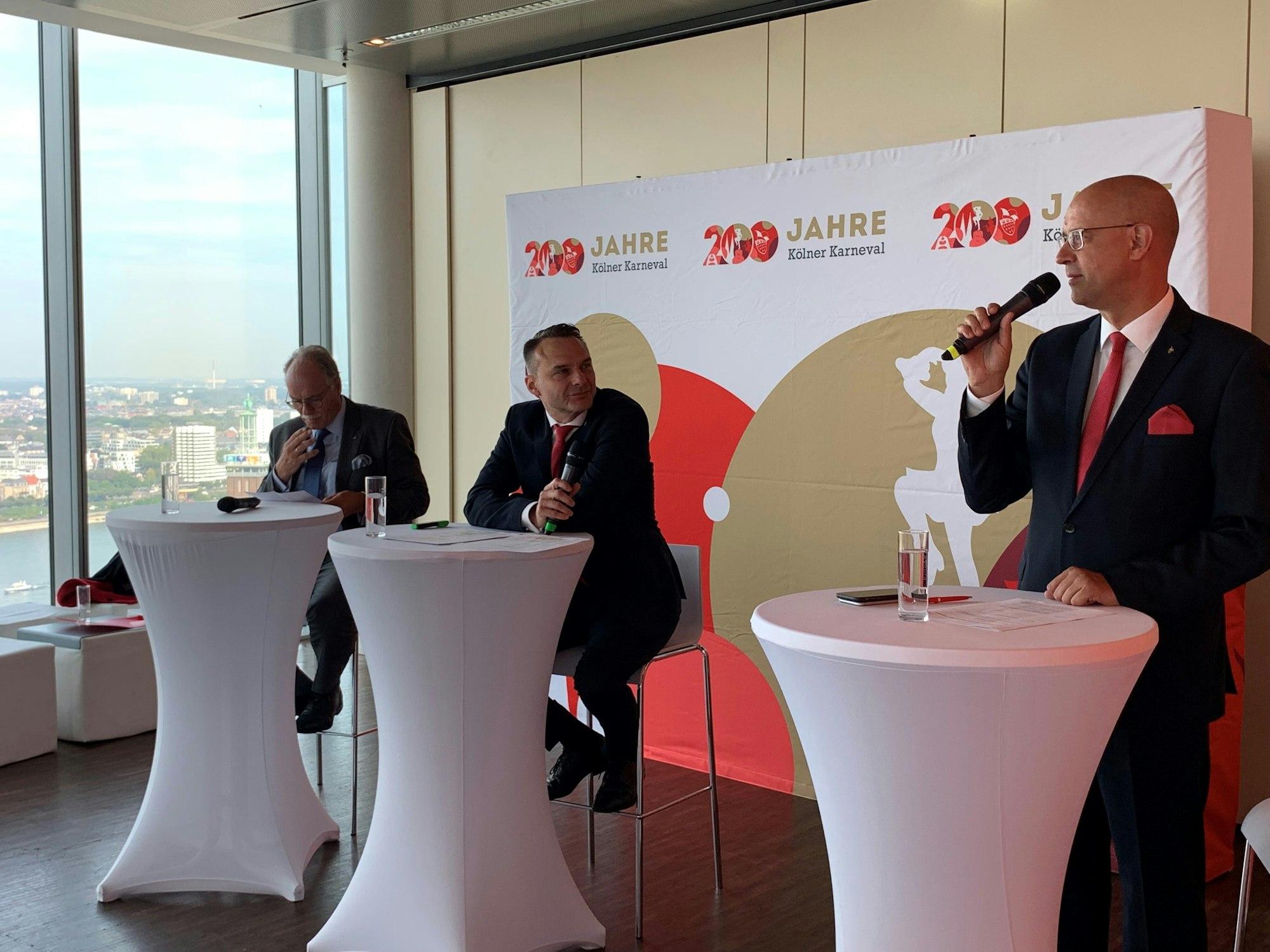 Kölnkongress-Chef Bernhard Conin, Holger Kirsch und FK-Sprecher Michael Kramp (v.l.) stehen an drei Pulten mit Mikrofonen in der Hand