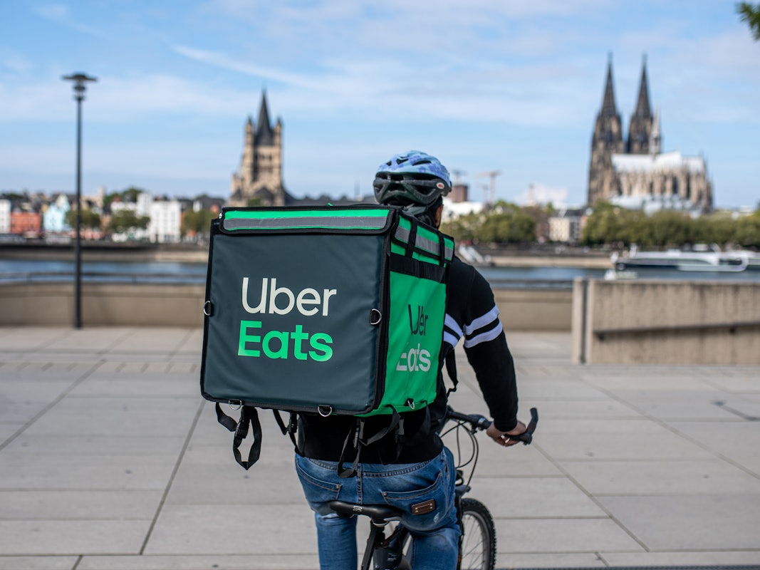 Ein Radfahrer mit großer Essenstasche von Uber Eats auf dem Rücken.