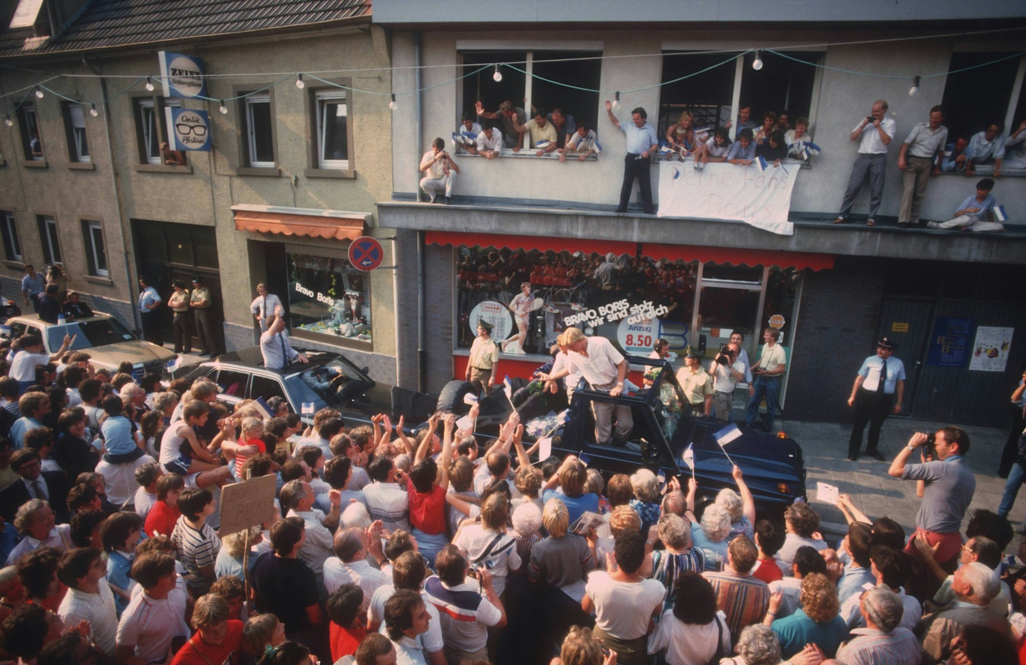 Boris Becker in einem Auto zwischen zahlreichen Fans