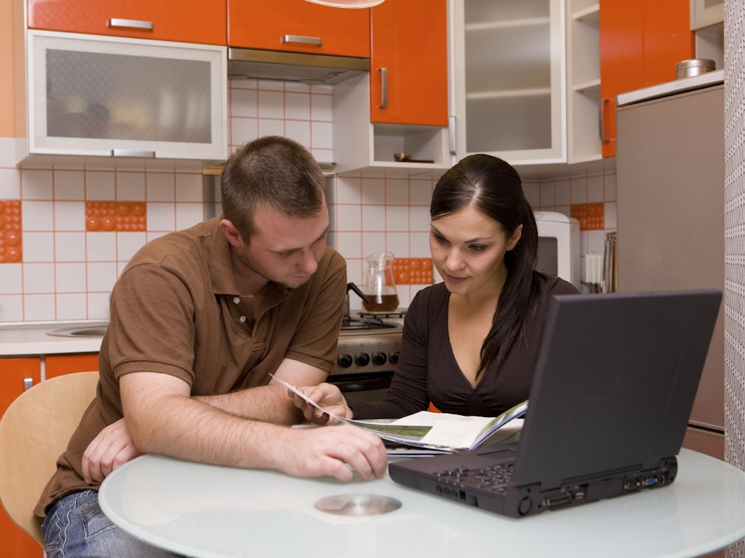 Ein Ehepaar sitzt am Tisch und prüft die Finanzen. Ausblick Oktober 2021: Das ändert sich für Verbraucher.
