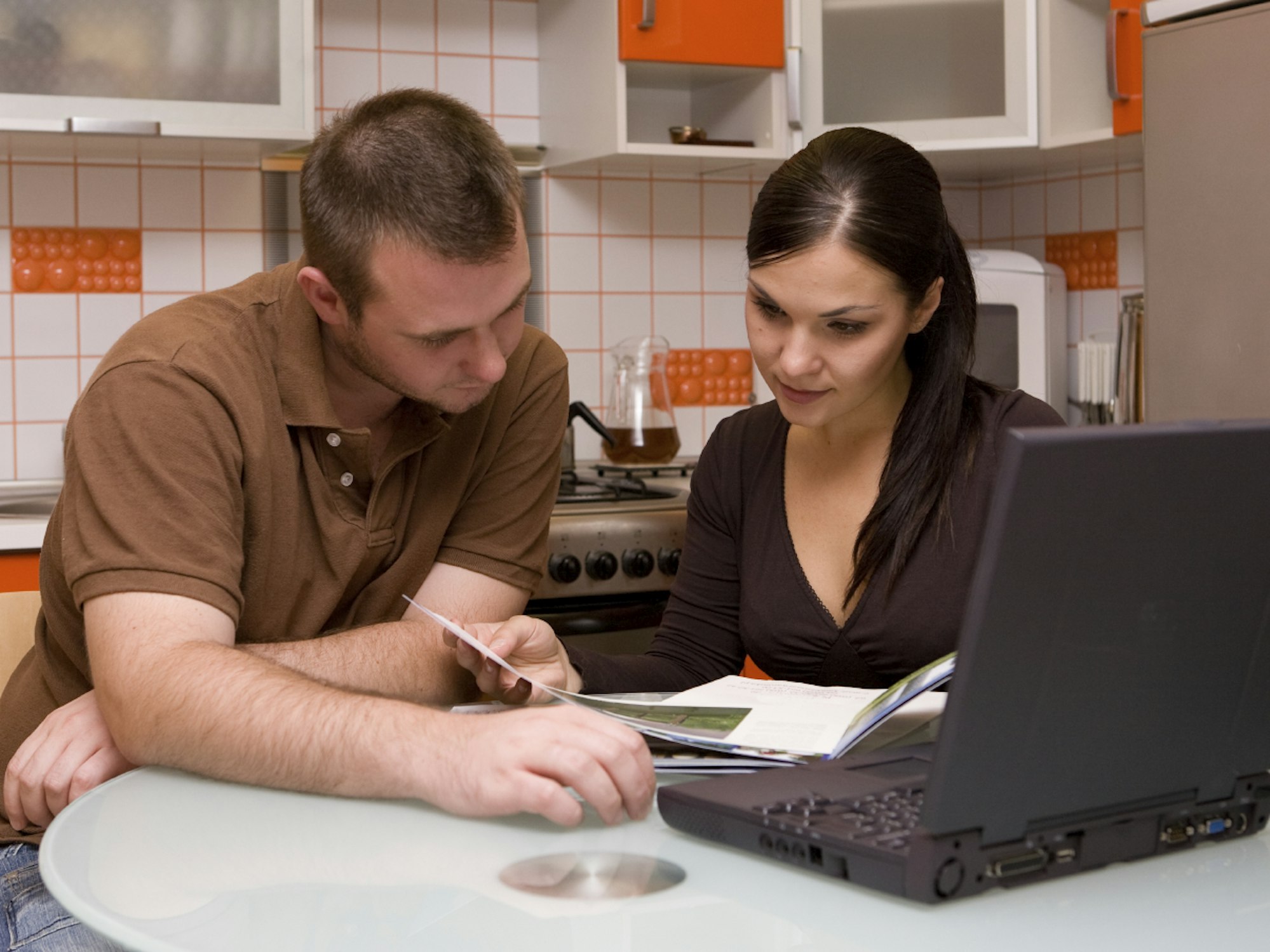 Ein Ehepaar sitzt am Tisch und prüft die Finanzen. Ausblick Oktober 2021: Das ändert sich für Verbraucher.