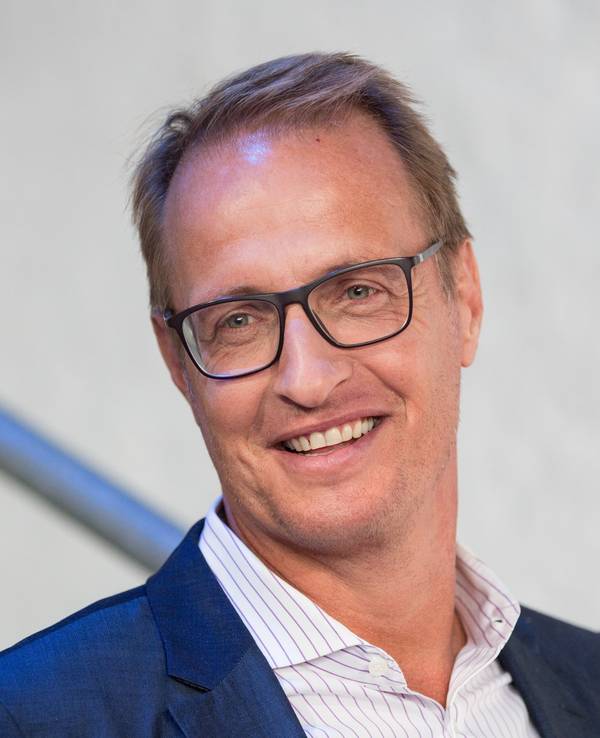Moderator Florian König lächelt in die Kamera.