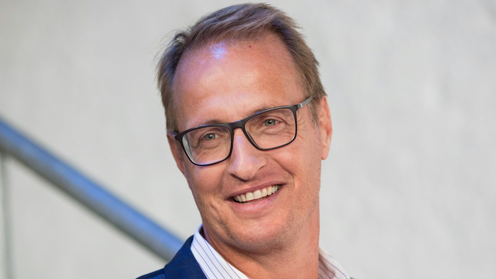 Moderator Florian König lächelt in die Kamera.