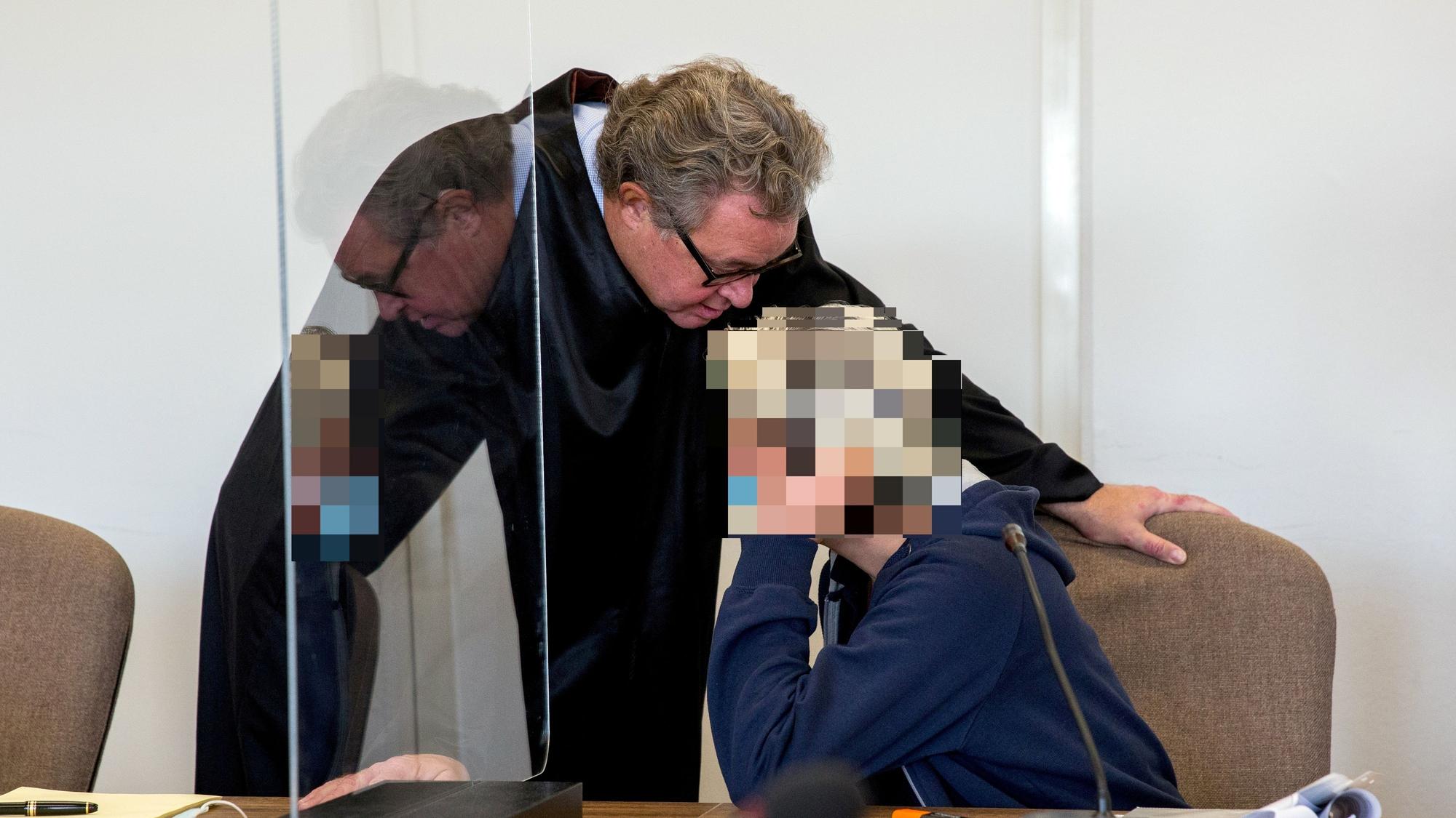 Angeklagte und Anwalt unterhalten sich im Gericht.