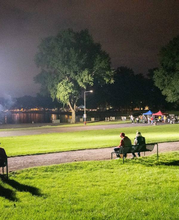 Mehrere Personen sitzen am Aachener Weiher.