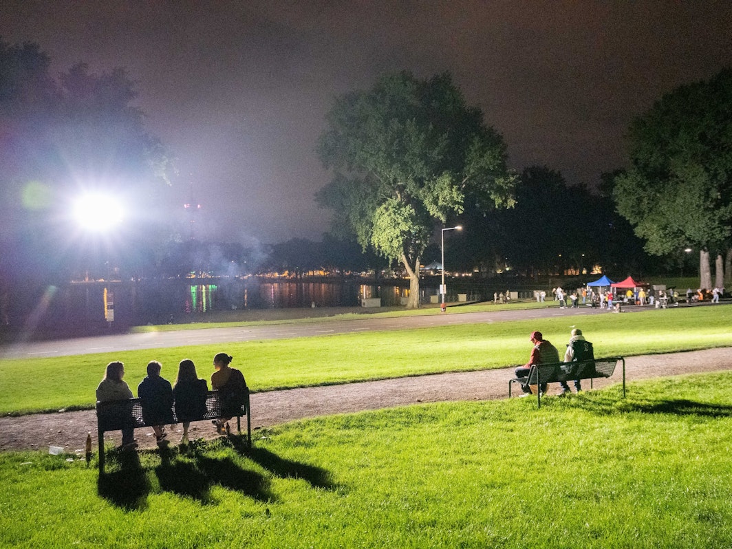 Mehrere Personen sitzen am Aachener Weiher.