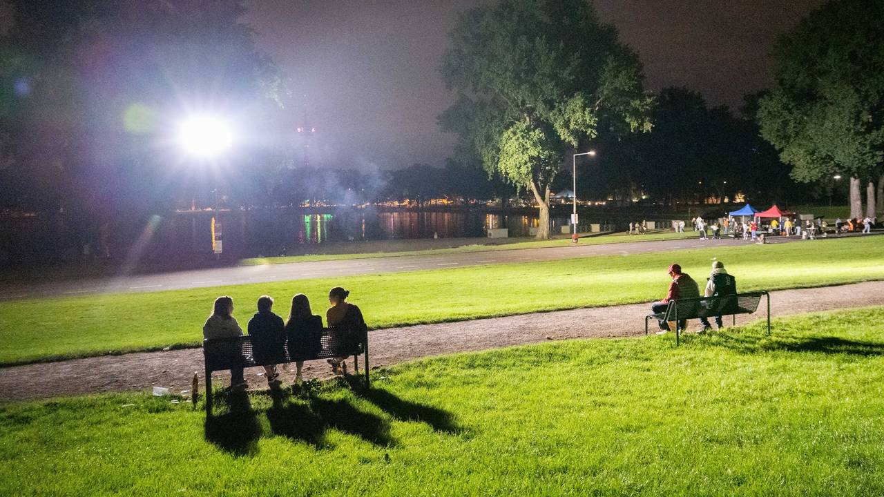 Mehrere Personen sitzen am Aachener Weiher.