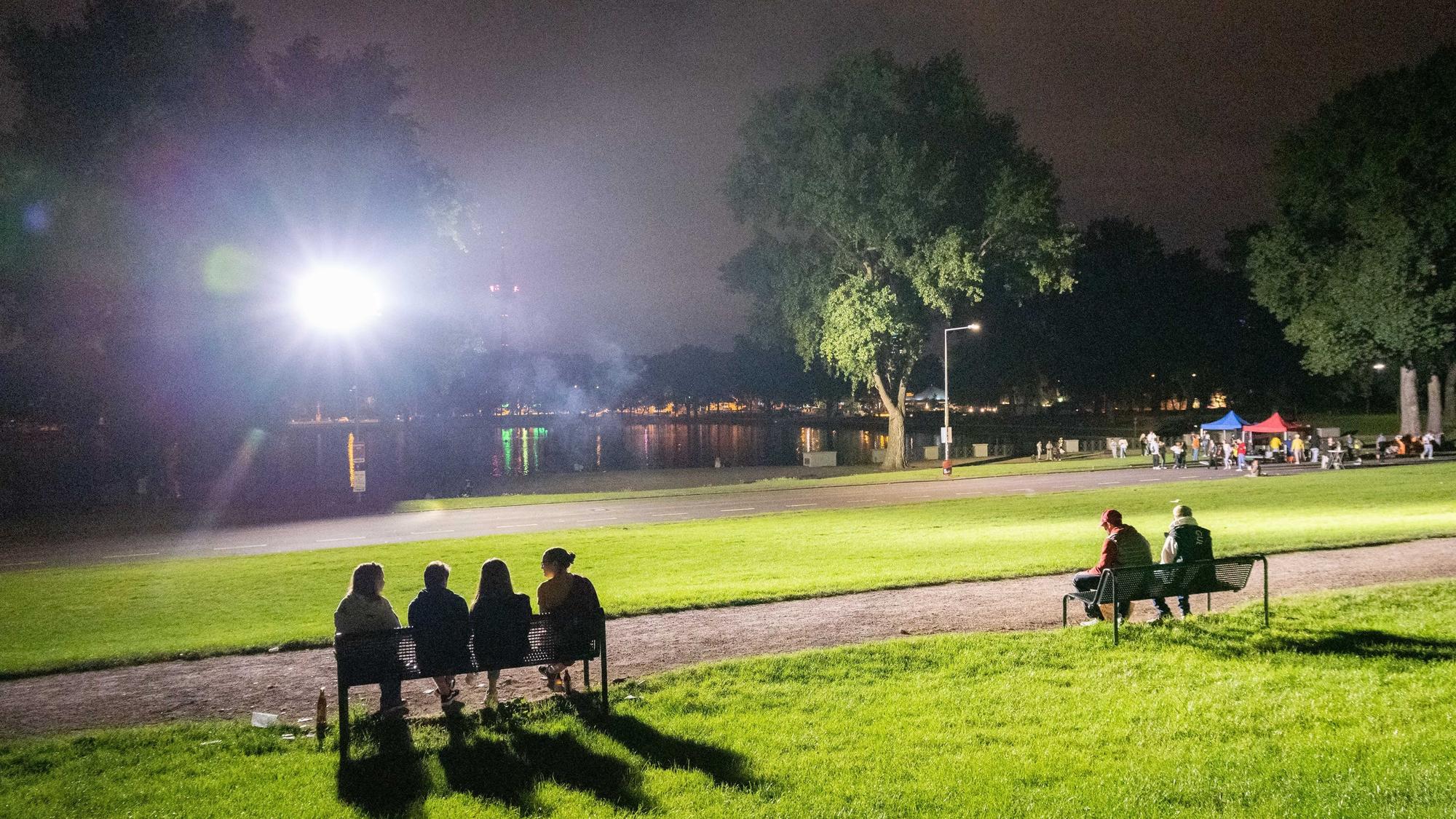 Mehrere Personen sitzen am Aachener Weiher.