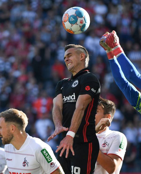 Frankfurts Rafael Santos Borre (M) versucht vor Kölns Torwart Timo Horn (r) an den Ball zu kommen.