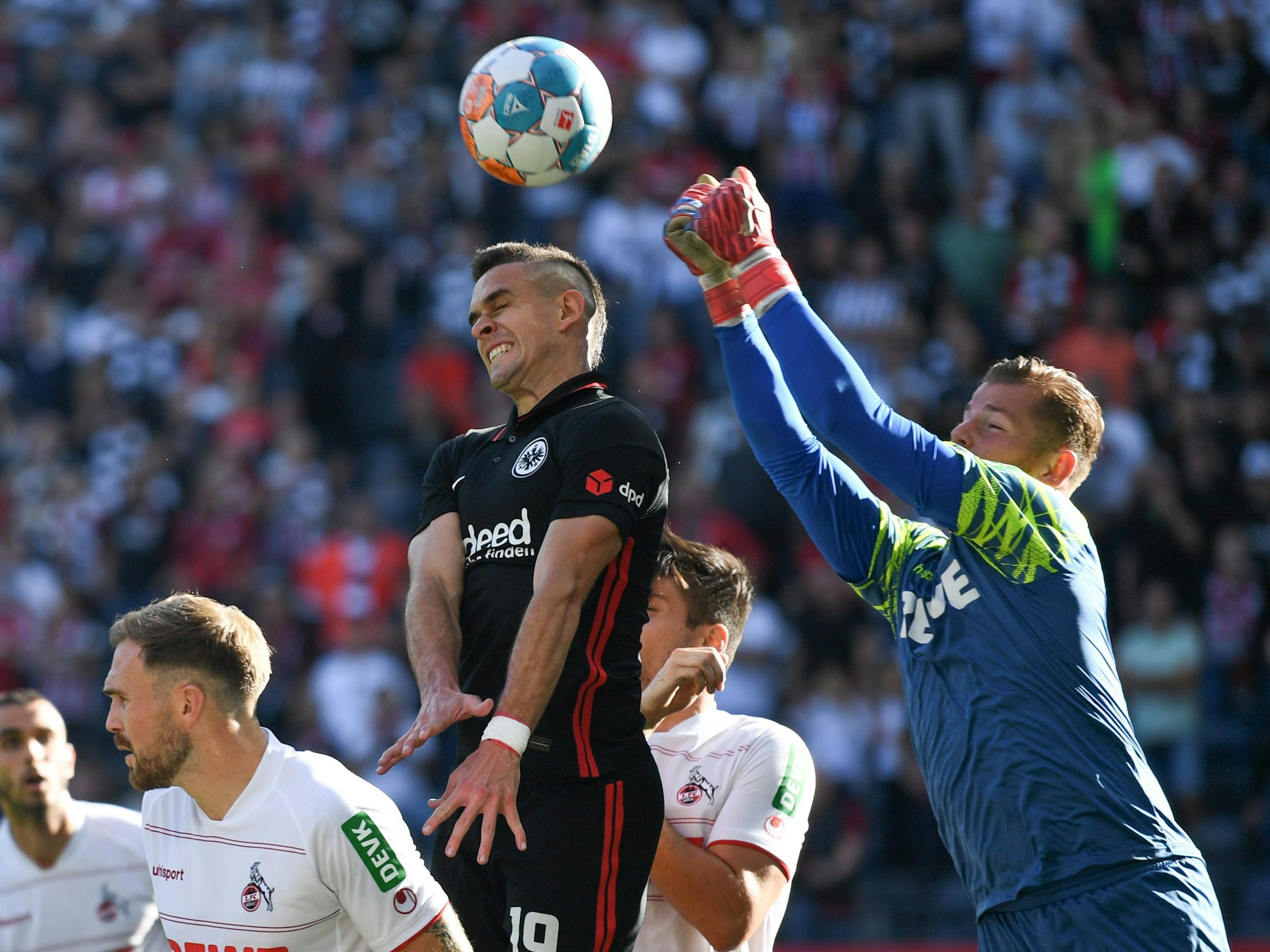 Frankfurts Rafael Santos Borre (M) versucht vor Kölns Torwart Timo Horn (r) an den Ball zu kommen.