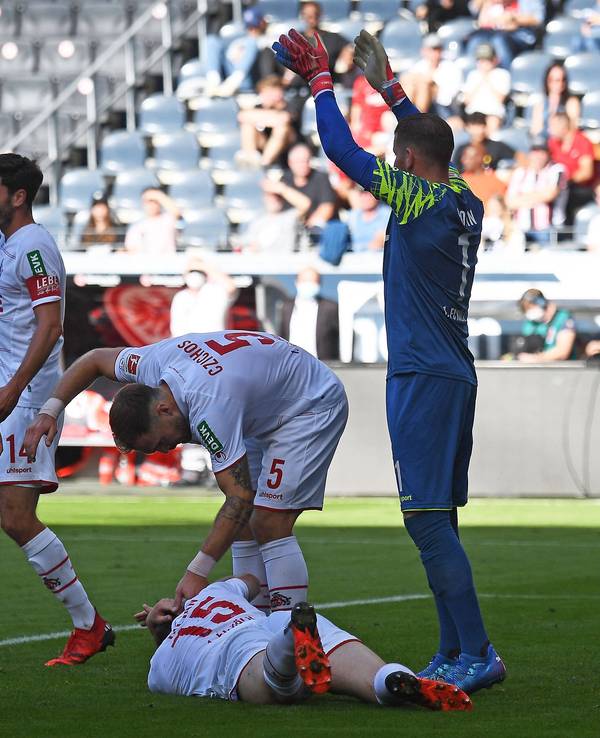 Luca Kilian liegt beim Spiel Eintracht Frankfurt gegen 1. FC Köln auf dem Rasen.