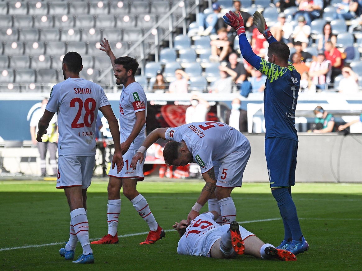 Luca Kilian liegt beim Spiel Eintracht Frankfurt gegen 1. FC Köln auf dem Rasen.