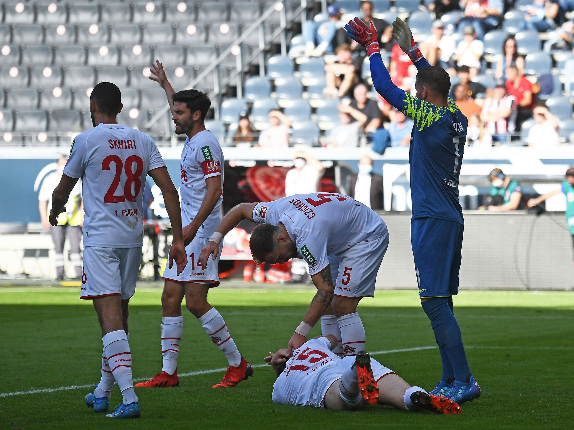 Luca Kilian liegt beim Spiel Eintracht Frankfurt gegen 1. FC Köln auf dem Rasen.