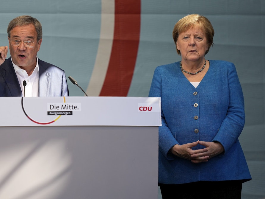 CDU-Kanzlerkandidat Armin Laschet und Noch-Kanzlerin Angela Merkel bei ihrem gemeinsamen Wahlkampfauftritt am Samstag, 25. September, in Aachen. Laschet spricht ins Mikro, Merkel steht daneben.