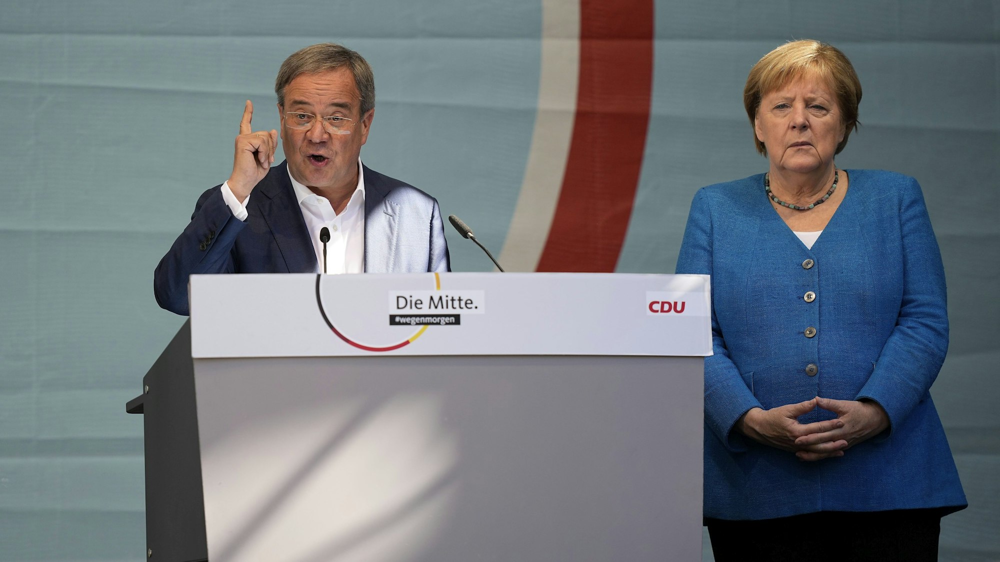 CDU-Kanzlerkandidat Armin Laschet und Noch-Kanzlerin Angela Merkel bei ihrem gemeinsamen Wahlkampfauftritt am Samstag, 25. September, in Aachen. Laschet spricht ins Mikro, Merkel steht daneben.