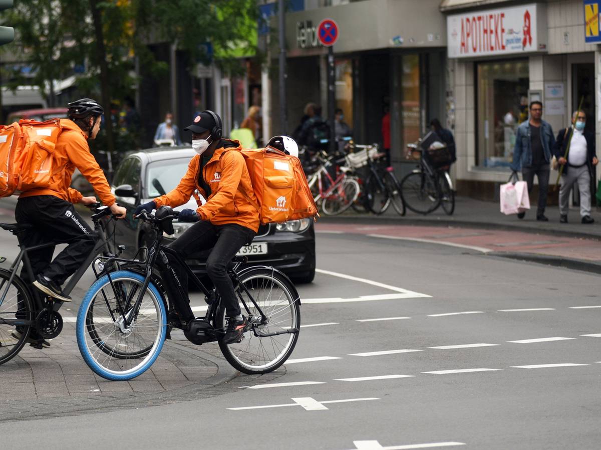 Zwei Lieferando-Fahrer fahren auf der Venloer Straße in Köln.