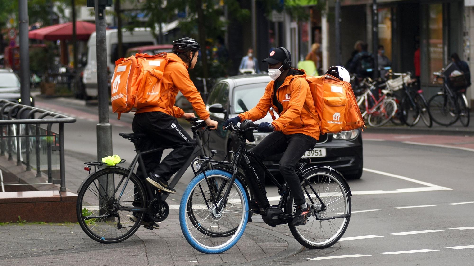 Zwei Lieferando-Fahrer fahren auf der Venloer Straße in Köln.