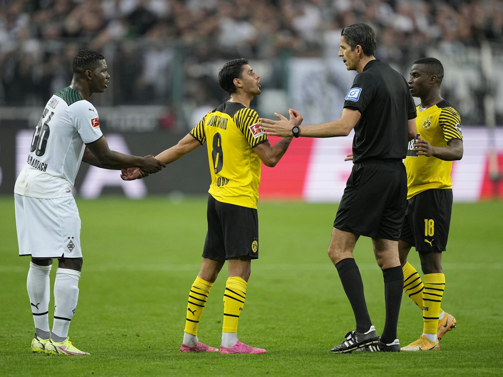 Deniz Aytekin diskutiert beim Bundesliga-Spiel Borussia Mönchengladbach gegen Borussia Dortmund mit Mahmoud Dahoud.