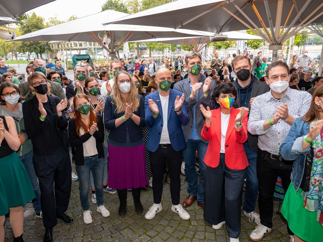 Die Direktkandidaten der Grünen Katharina Dröge und
Sven Lehmann stehen im Kreise mit anderen Parteimitgliedern und applaudieren.