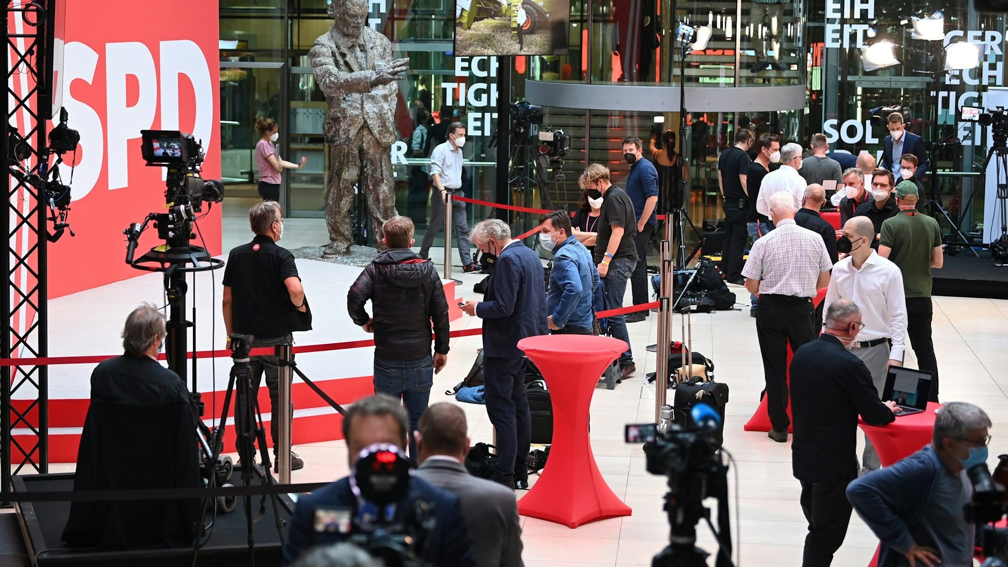 Journalisten stehen in der SPD-Parteizentrale vor der Skulptur von Willy Brandt.