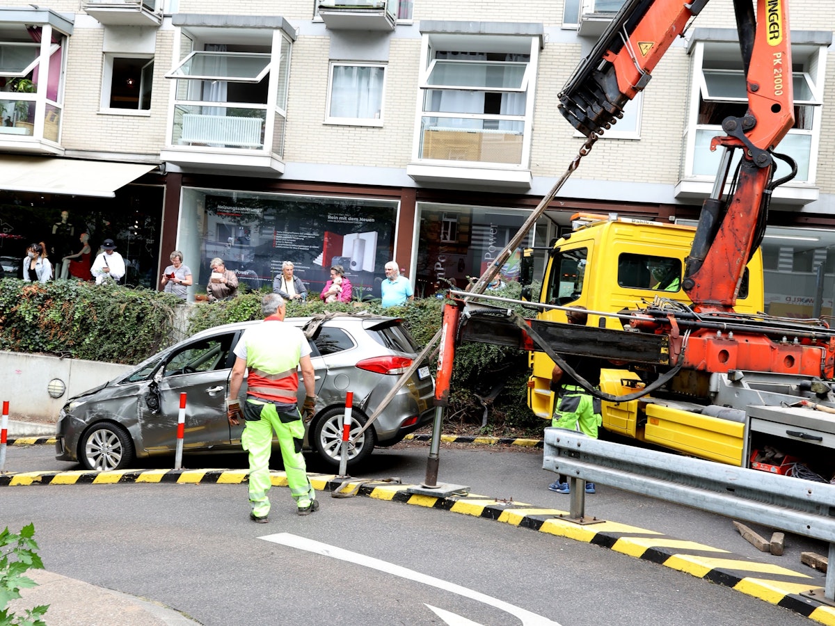 Ein Auto wird von einem Kran gezogen.