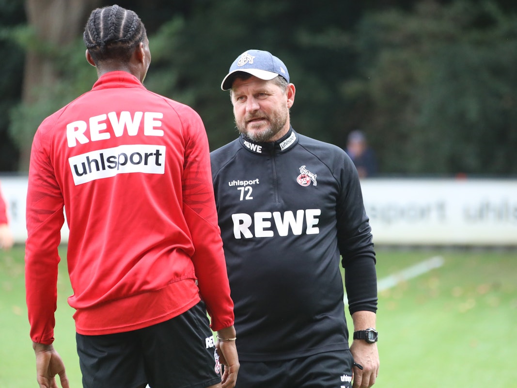 Steffen Baumgart spricht beim Training des 1. FC Köln mit Kingsley Ehizibue.