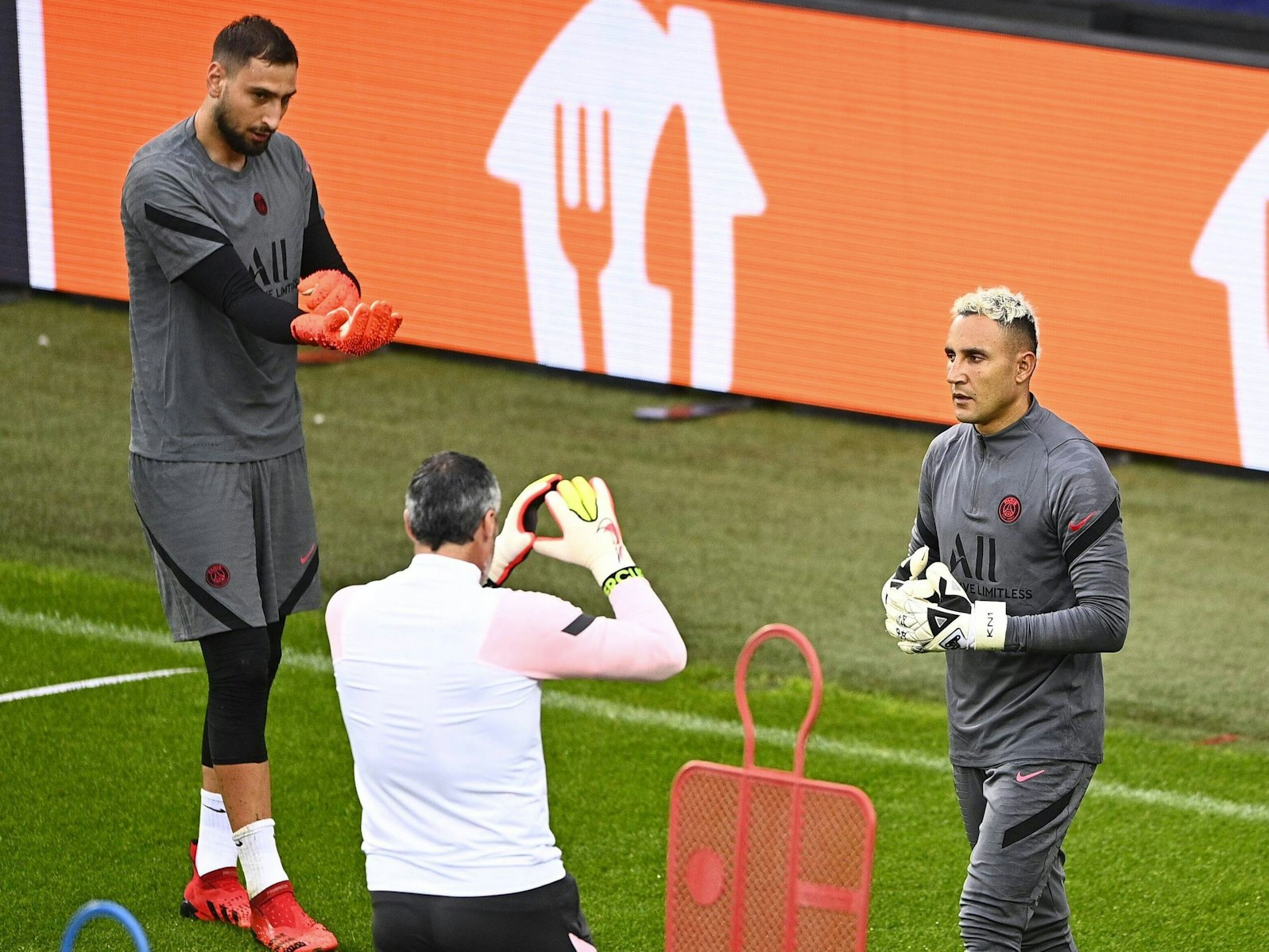 Donnarrumma zieht seine Handschuhe an, Navas bekommt Anweisungen vom Torwarttrainer.