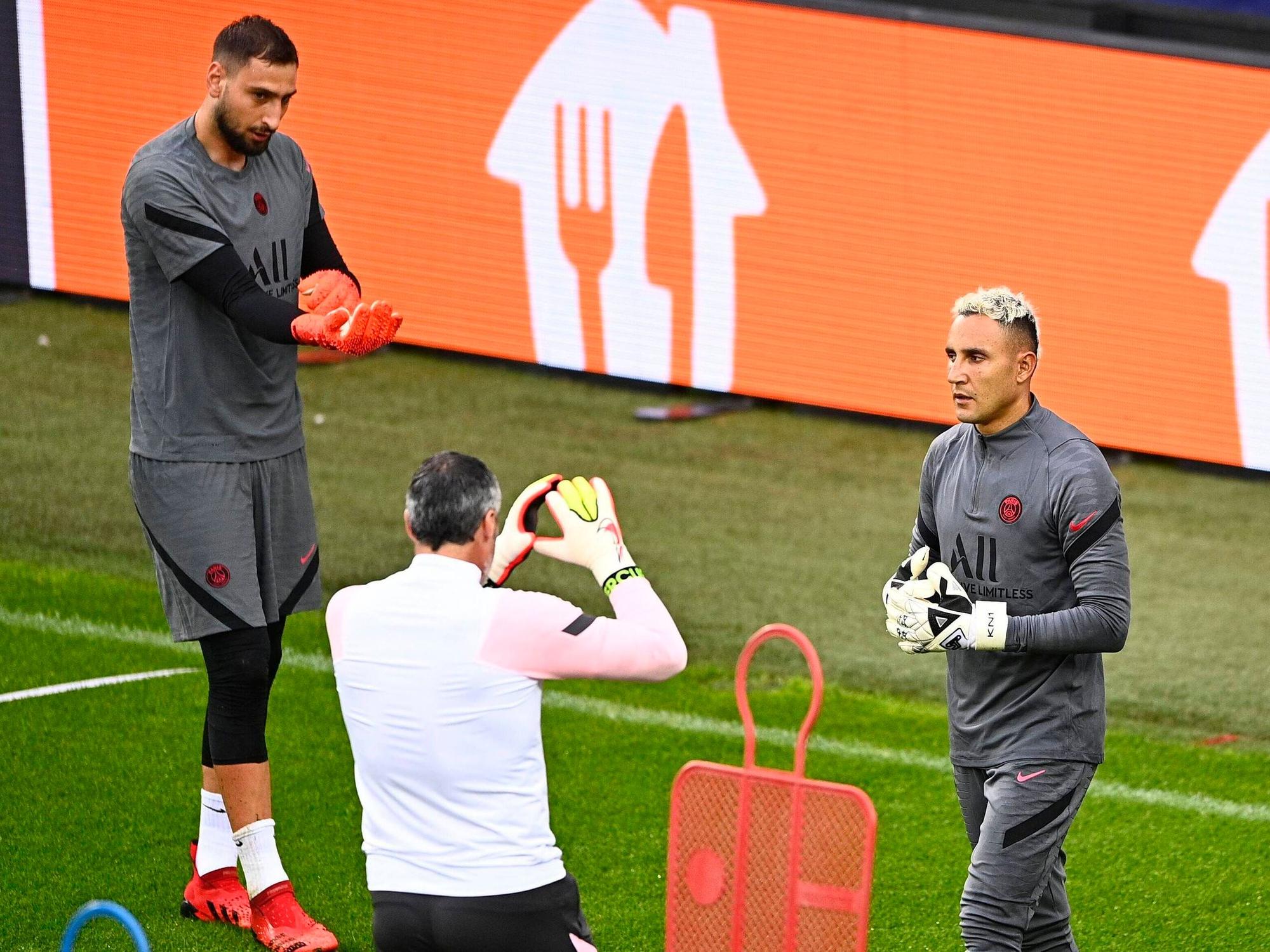 Donnarrumma zieht seine Handschuhe an, Navas bekommt Anweisungen vom Torwarttrainer.