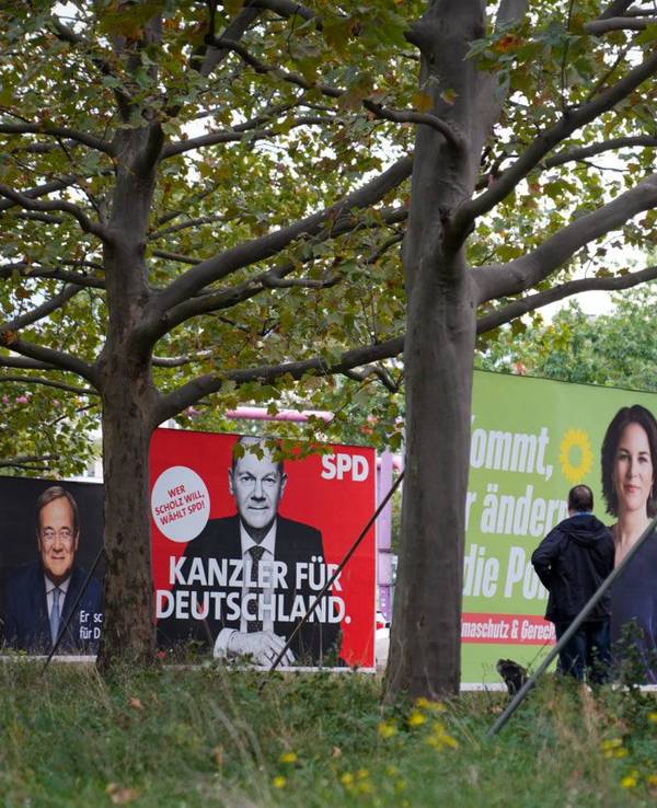 Wahlplakate der SPD mit Olaf Scholz, von Bündnis 90/Die Grünen mit Annalena Baerbock und der FDP mit Christian Lindner stehen auf einer Straße nebeneinander.