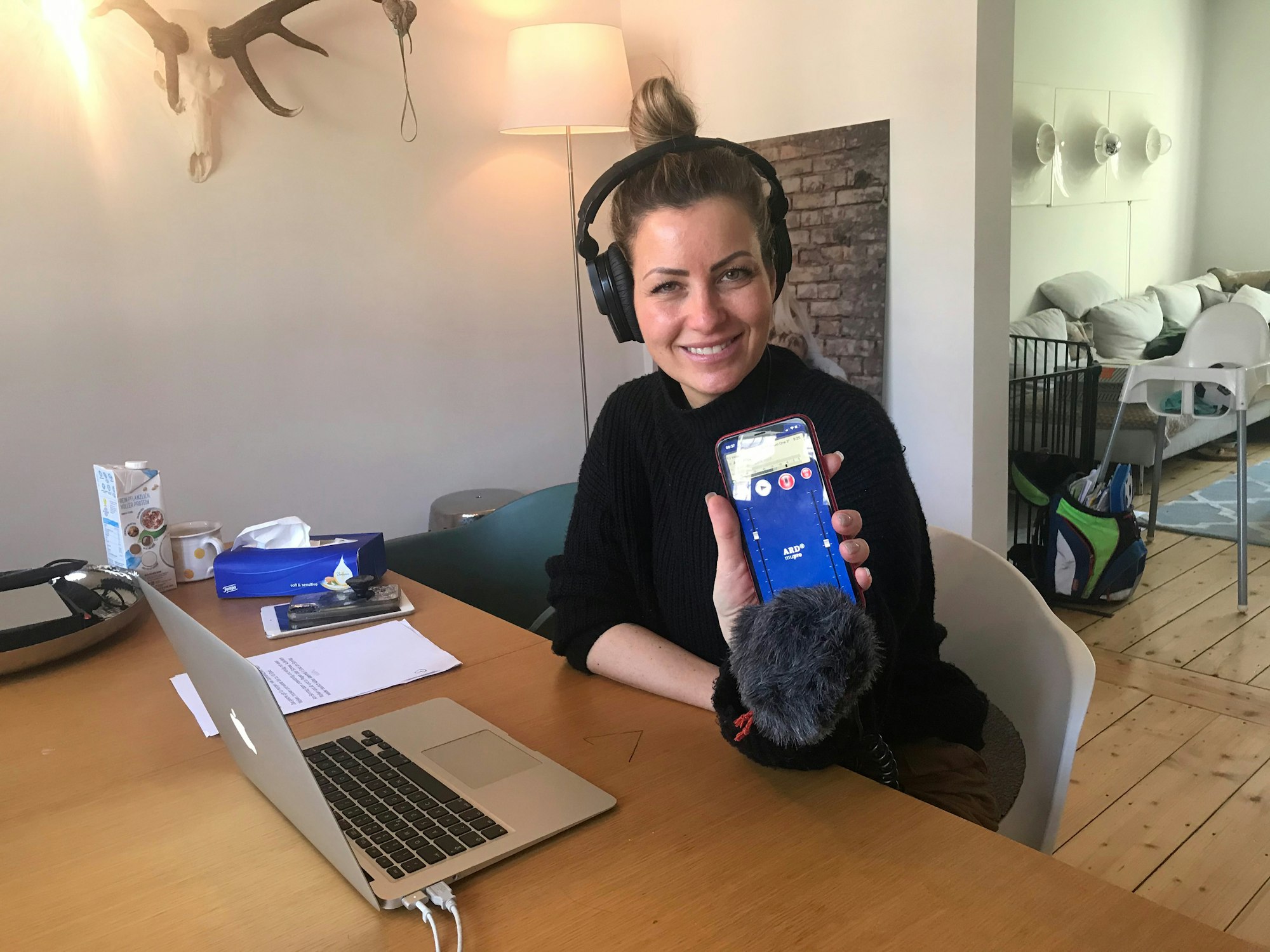 Radio-Moderatorin Susanka Kröger sitzt an einem Tisch in ihrer Wohnung, in der sie die Morningshow des Radiosenders YOU FM moderiert.