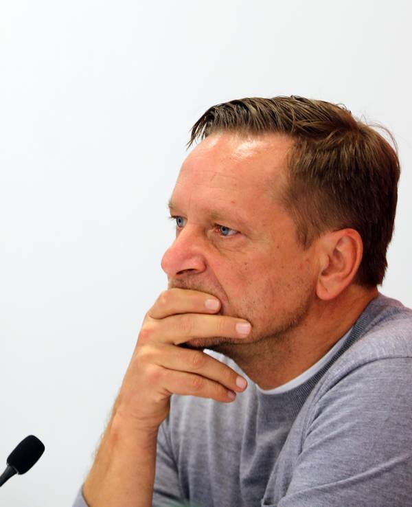 Horst Heldt fährt sich bei einer Pressekonferenz des 1. FC Köln mit den Händen durch das Gesicht.