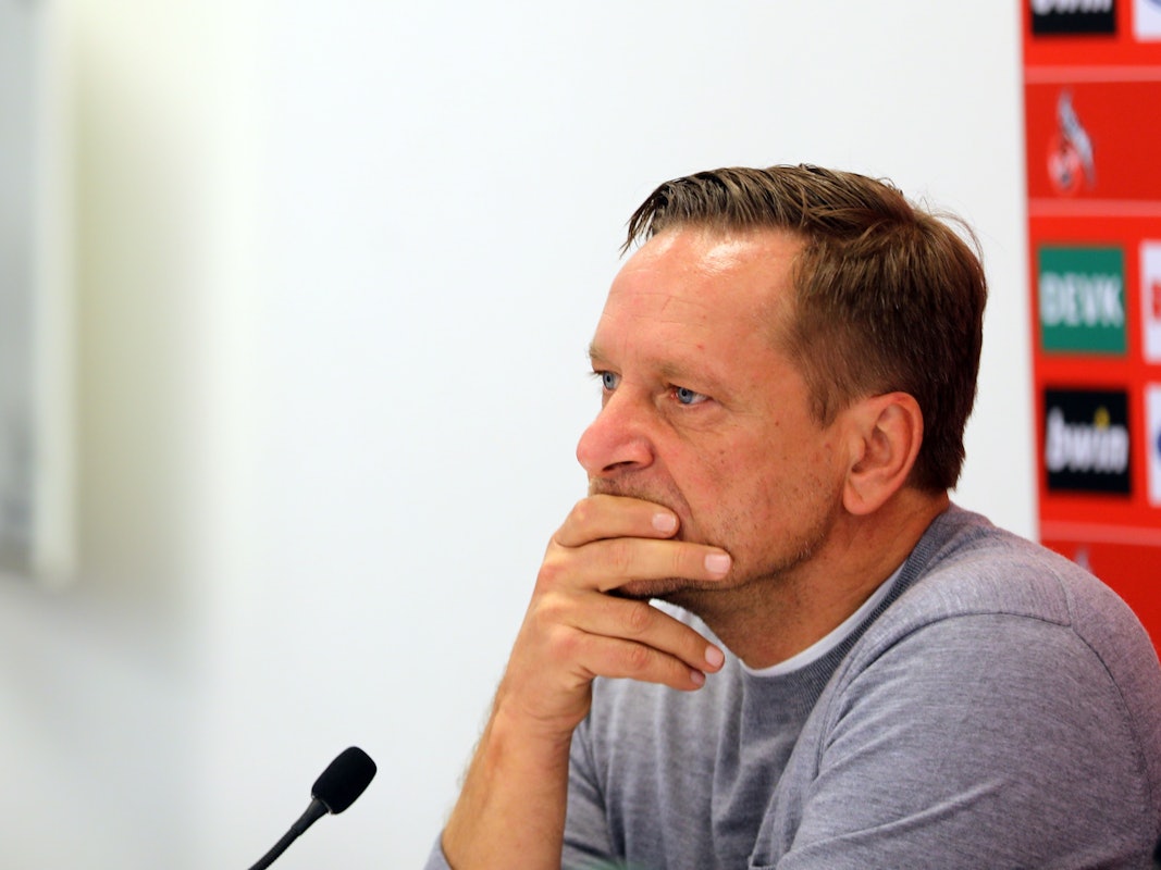 Horst Heldt fährt sich bei einer Pressekonferenz des 1. FC Köln mit den Händen durch das Gesicht.