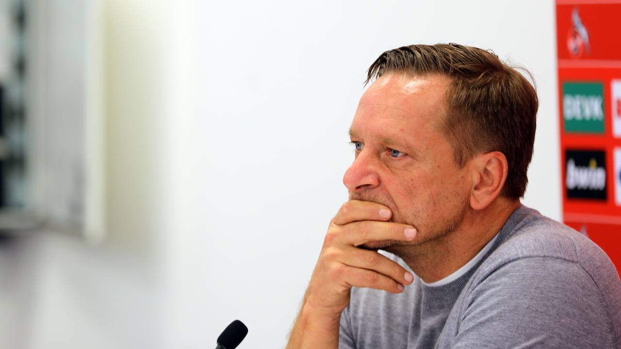 Horst Heldt fährt sich bei einer Pressekonferenz des 1. FC Köln mit den Händen durch das Gesicht.