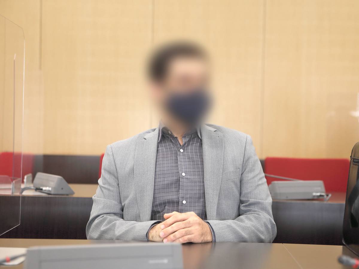 Der angeklagte Arzt sitzt mit Maske im Saal des Landgerichts.