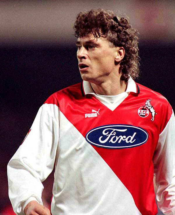 Toni Polster ist fokussiert. Er trägt ein rot-weißes Köln-Trikot von Puma mit dem Ford-Logo auf der Brust.